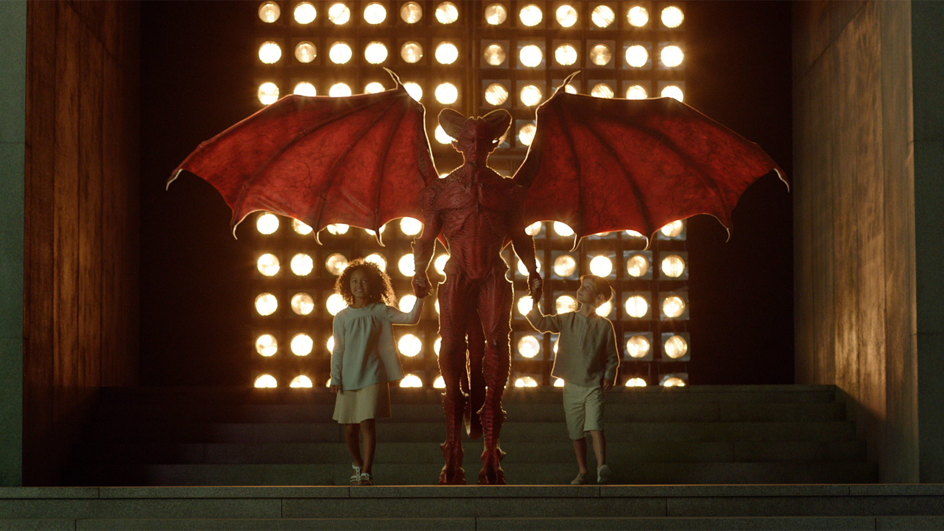 This meme features a photo of a young boy with a frightened expression, standing in front of a large, imposing creature with glowing red eyes. The creature appears to be a dragon or a monster from a fantasy movie. The text in the image reads: "When you're trying to do your homework but the demon in your basement is making too much noise."
